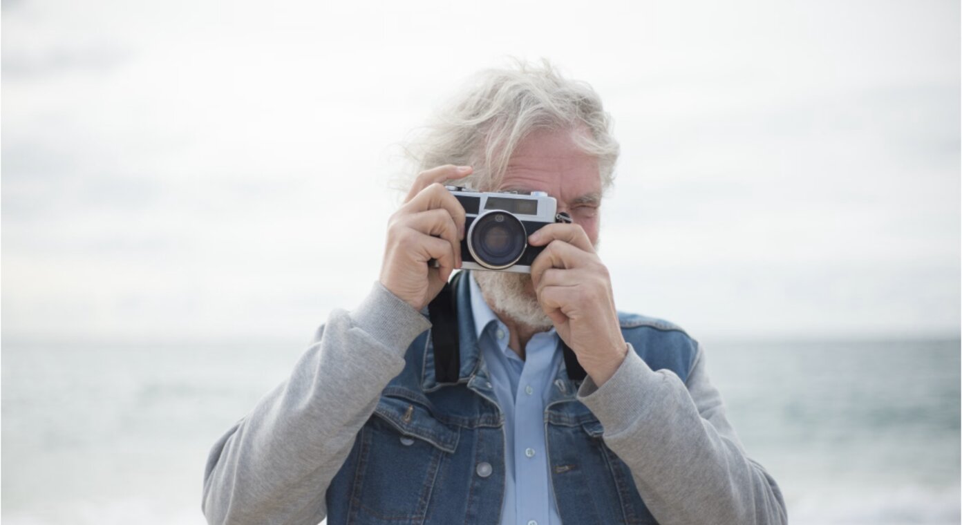 Person fotografiert mit einer Kamera im Freien